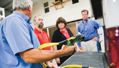 Getting a handle: Bob and Kathy Summers, center, tour Green-Spring Lawn Care Corp. with president James Young, far right.