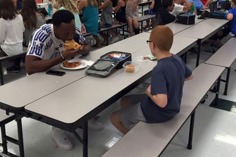 An FSU football player sits with an autistic boy for lunch.