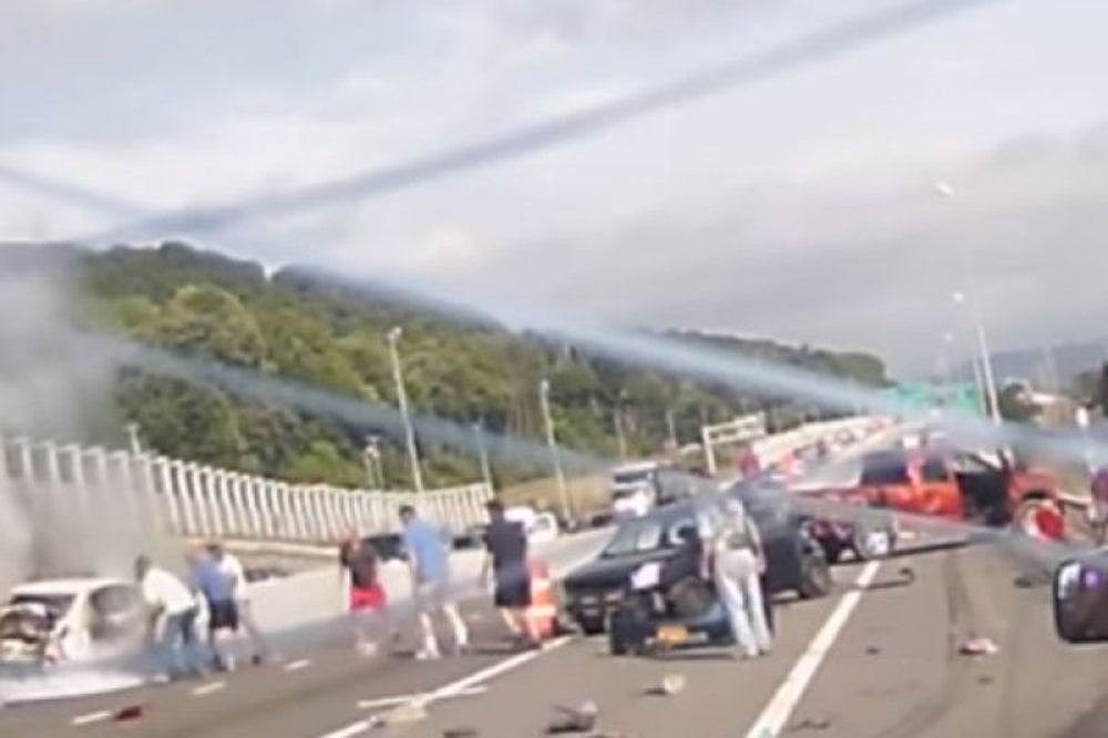 Motorists stop to help woman out of burning car.