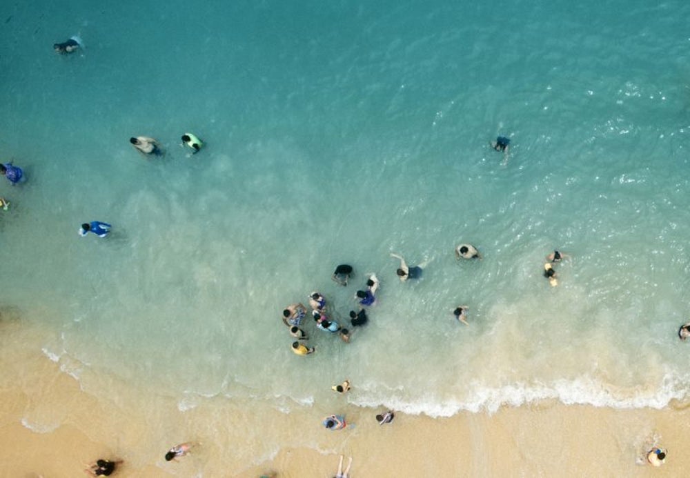 Beachgoers form human chain to rescue group of stranded swimmers.