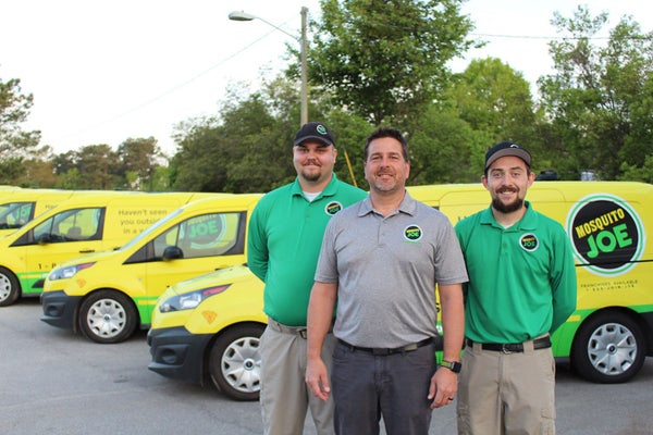 Employees Standing in front of Mosquito Joes trucks